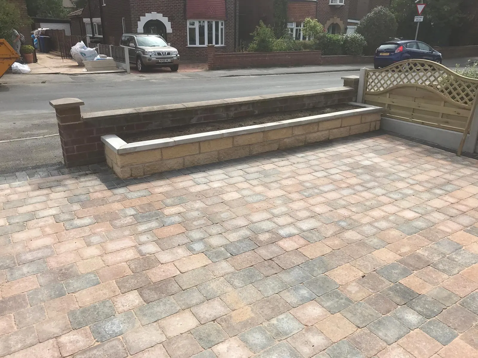 Block paved driveway with a low brick front wall