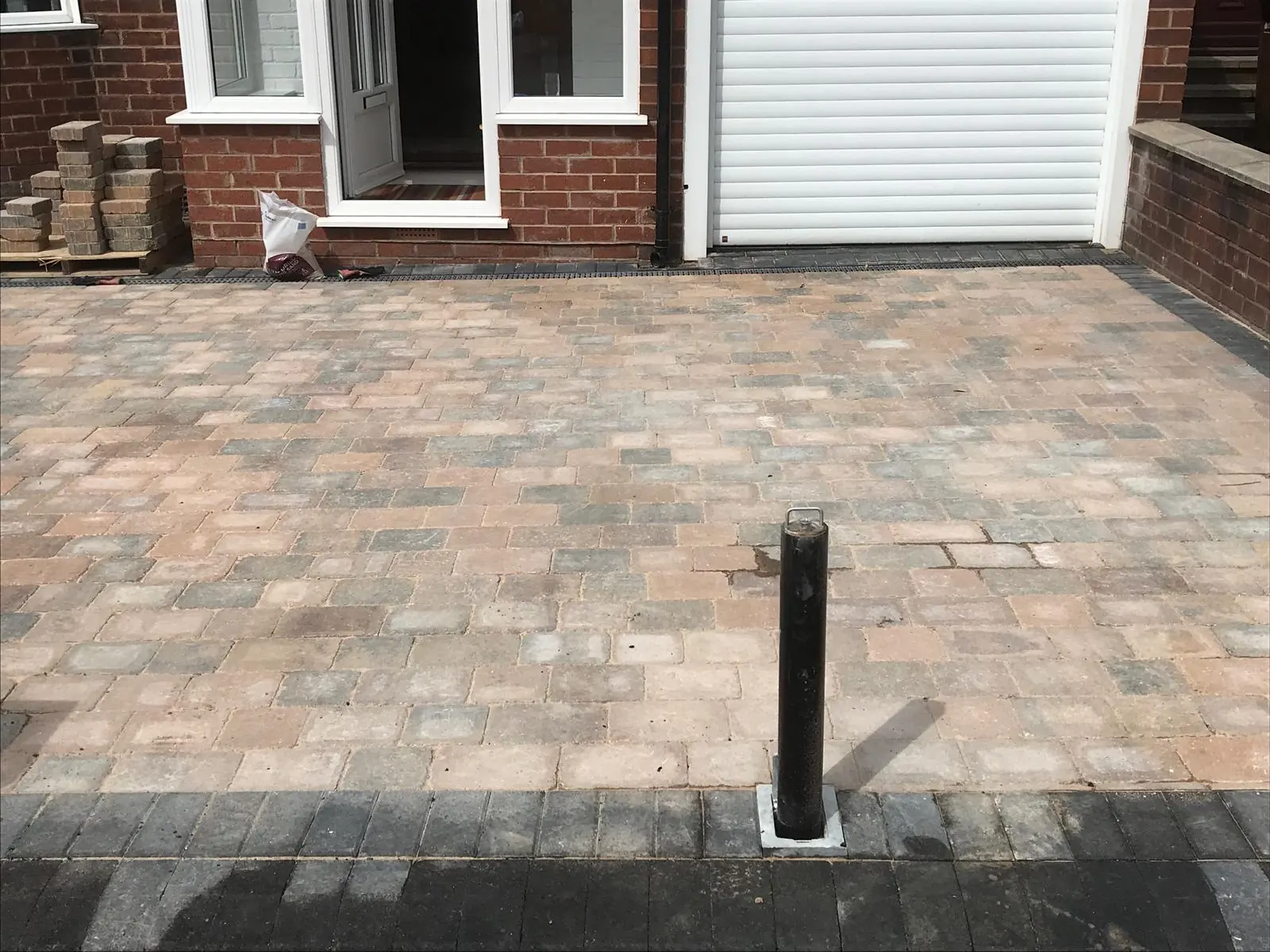 Block paved driveway with a security post in front of the garage