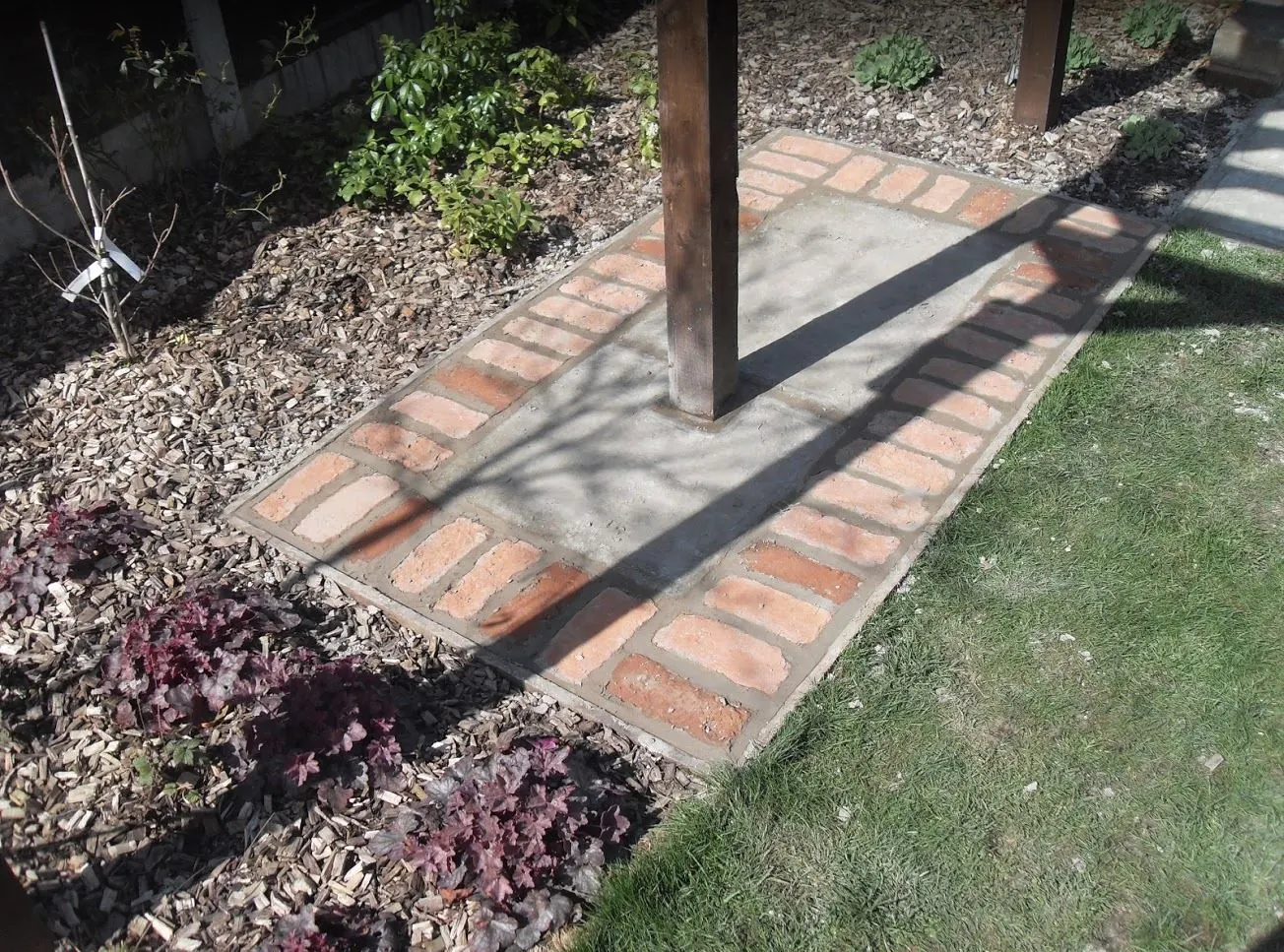 Brick and paving path leading through a landscaped garden