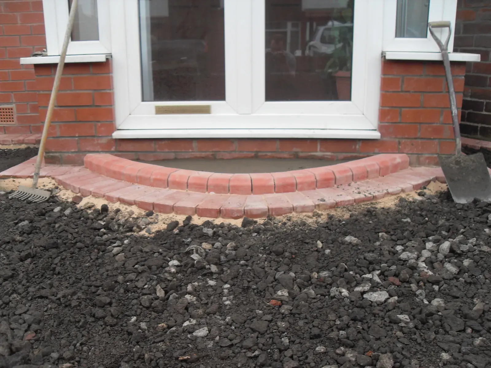 Curved brick step and edging formed outside patio doors