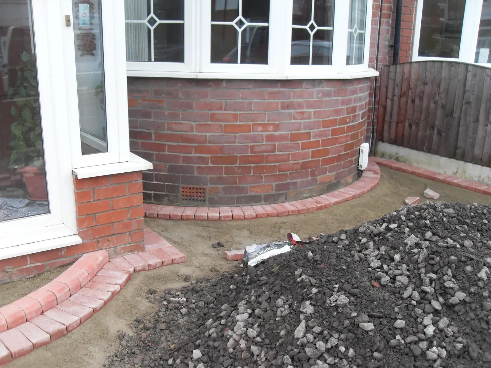 Curved red brick wall built to follow a bay window