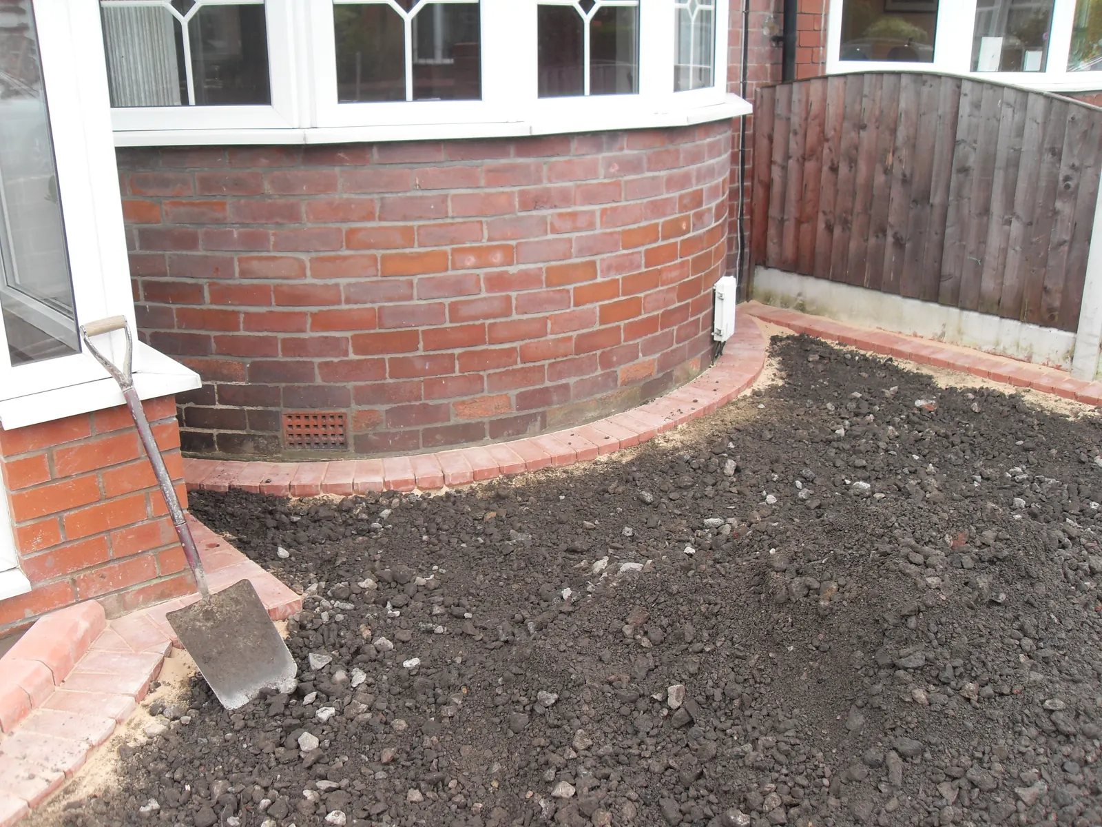 Before: the front garden dug out and edged in brick, ready for the sub-base