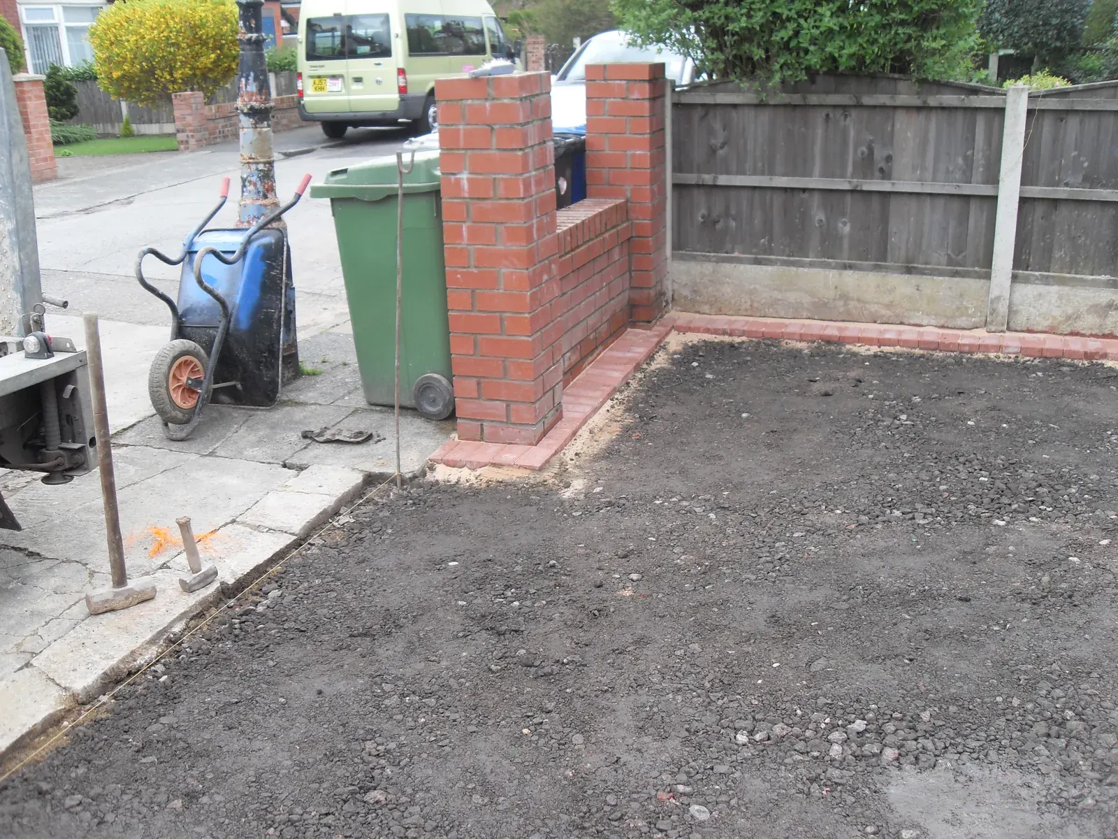 Driveway groundwork in progress between new brick pillars