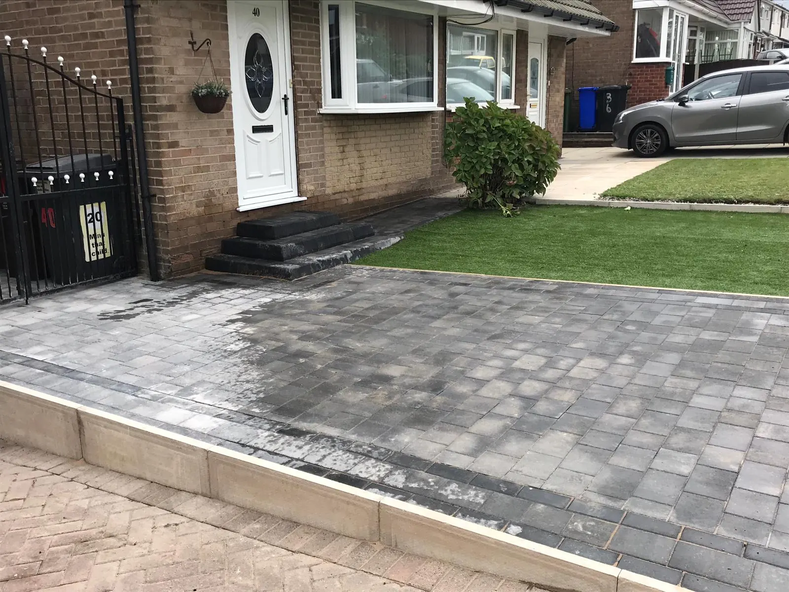 Grey block paved driveway with a new lawn edge