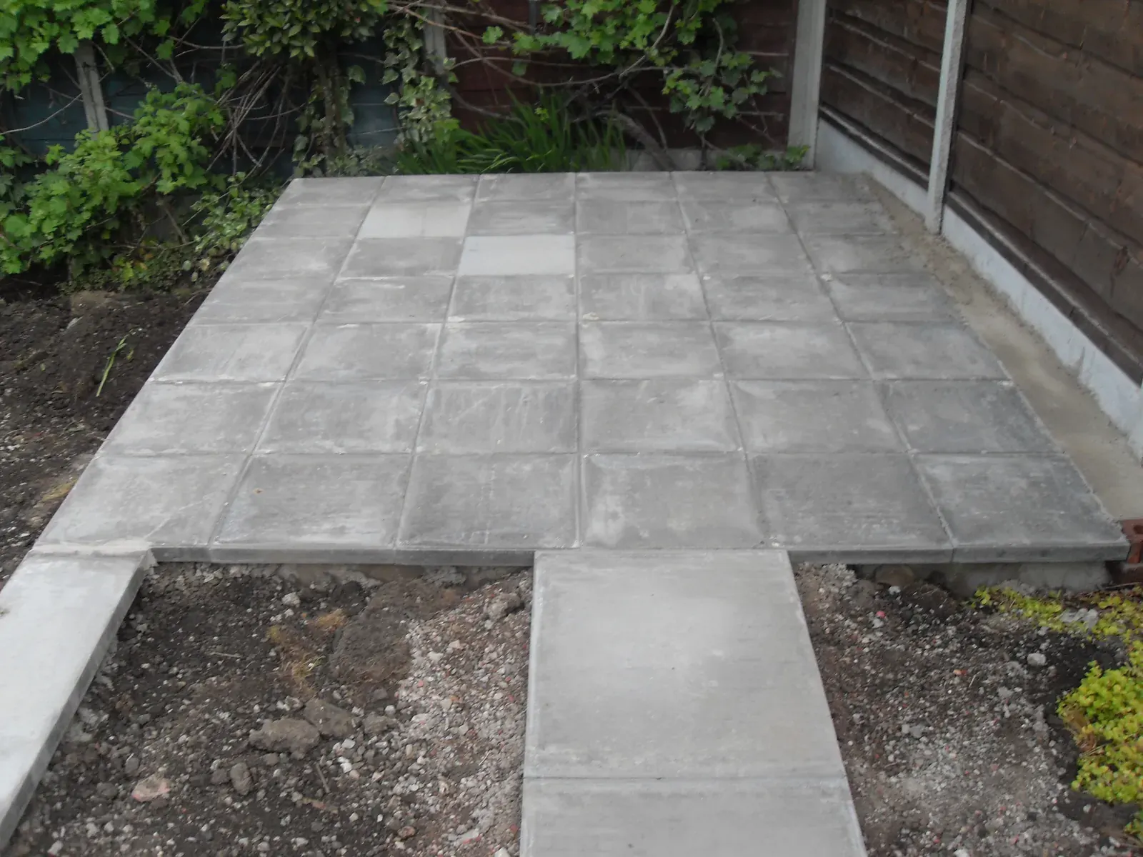 Grey paving slabs laid across a domestic garden patio