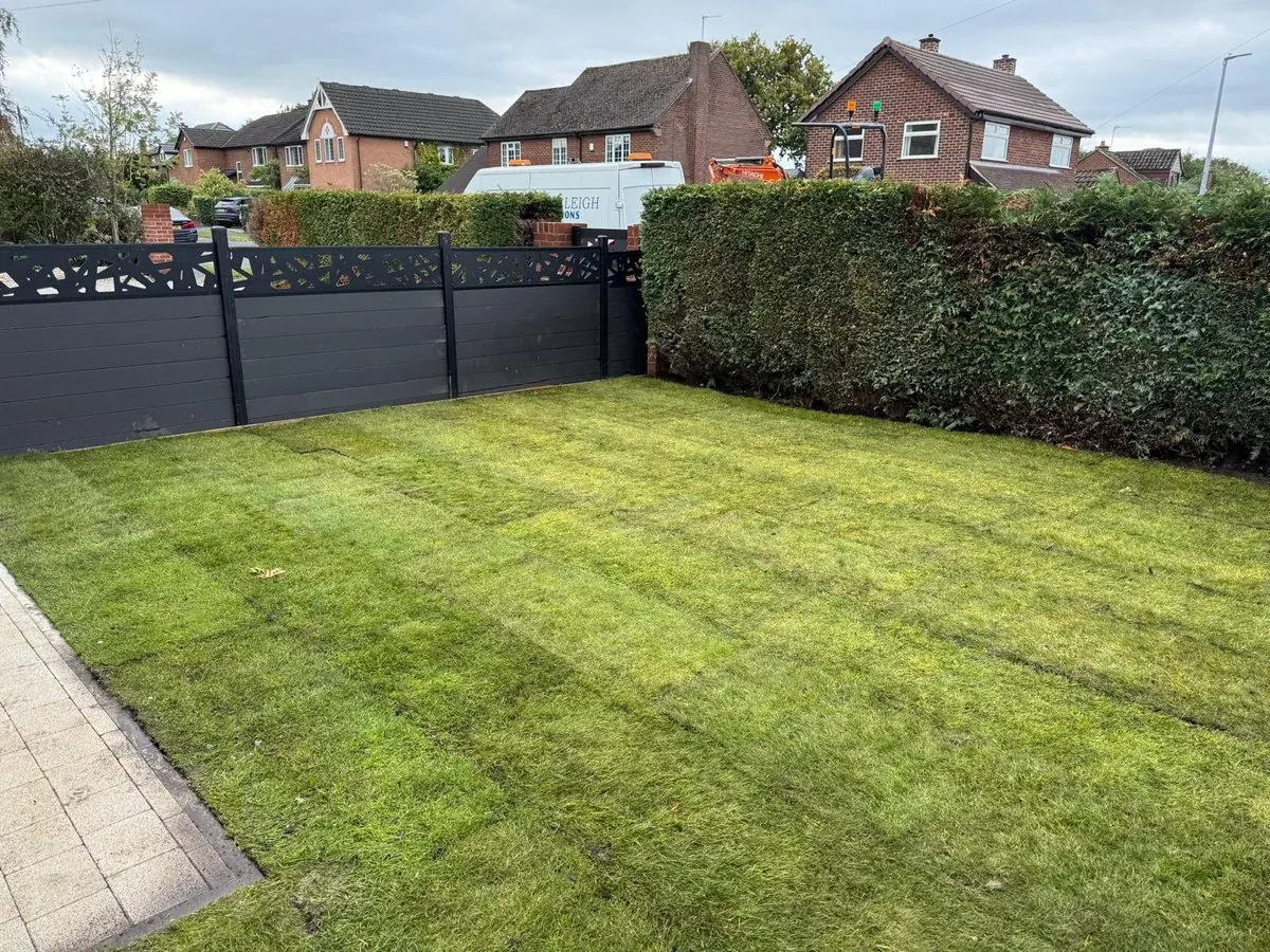 Landscaped lawn with new dark timber fencing and gate