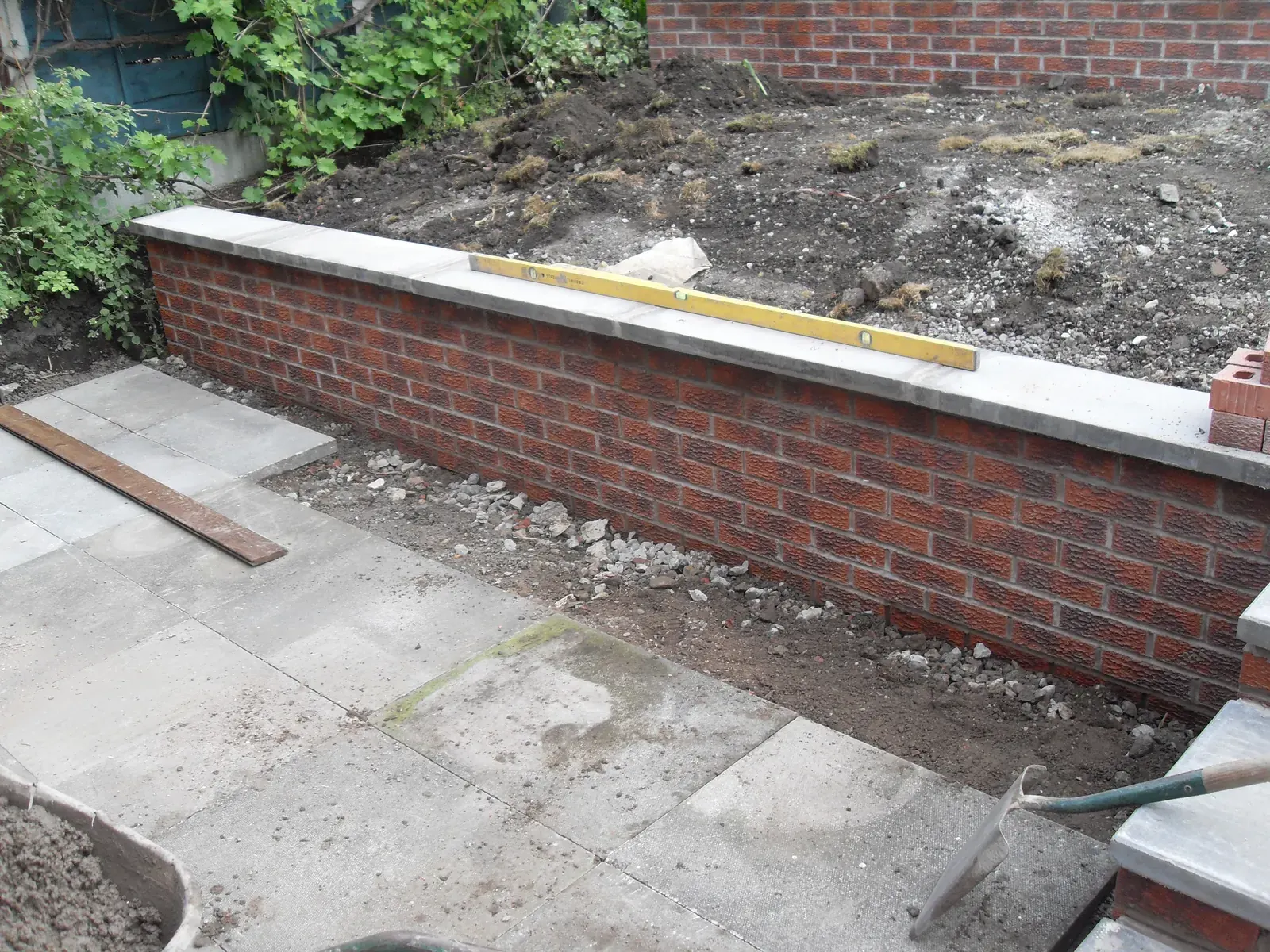 Long brick retaining wall checked to level during construction