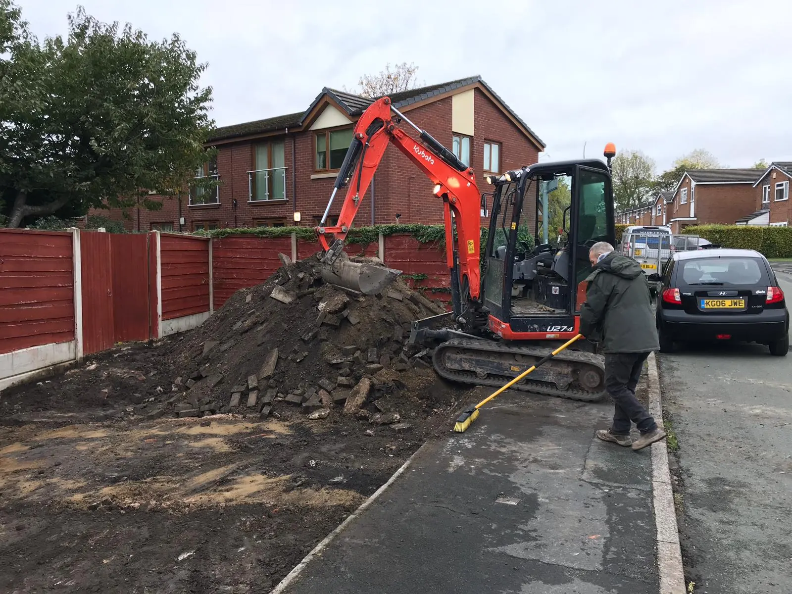 Mini excavator digging out beside a residential road