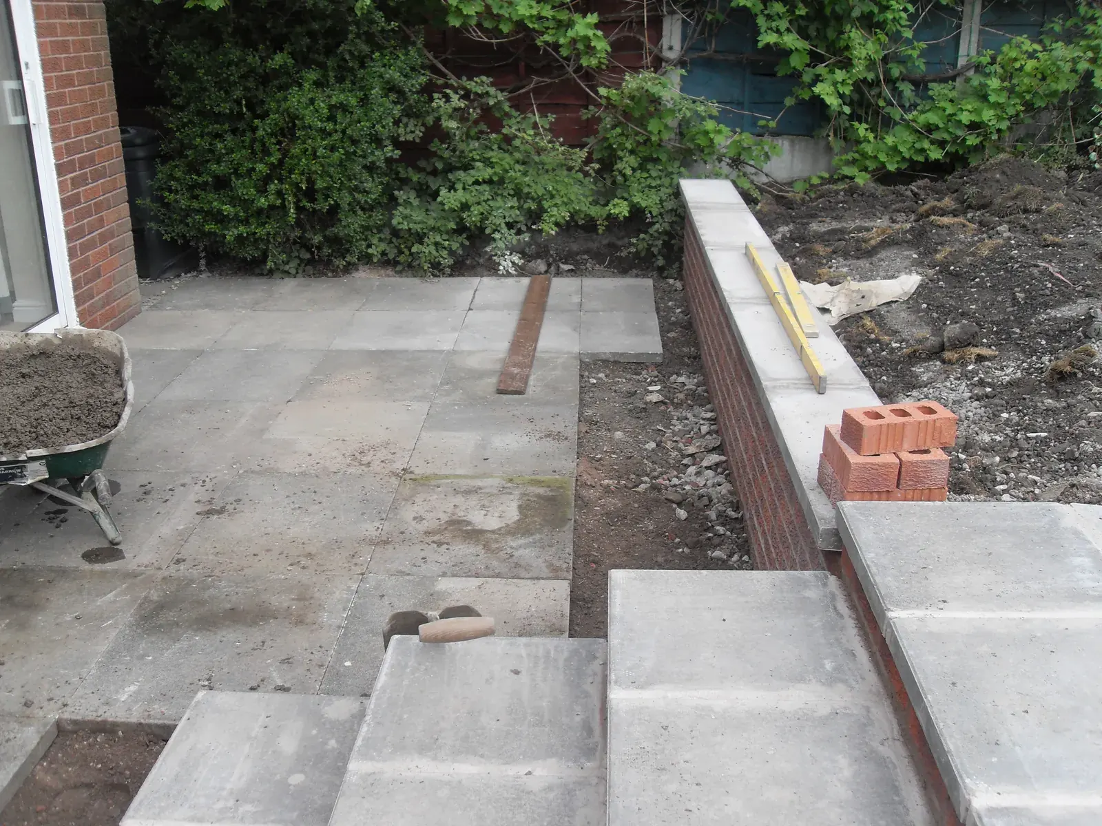 Paving and brick steps laid alongside a house wall