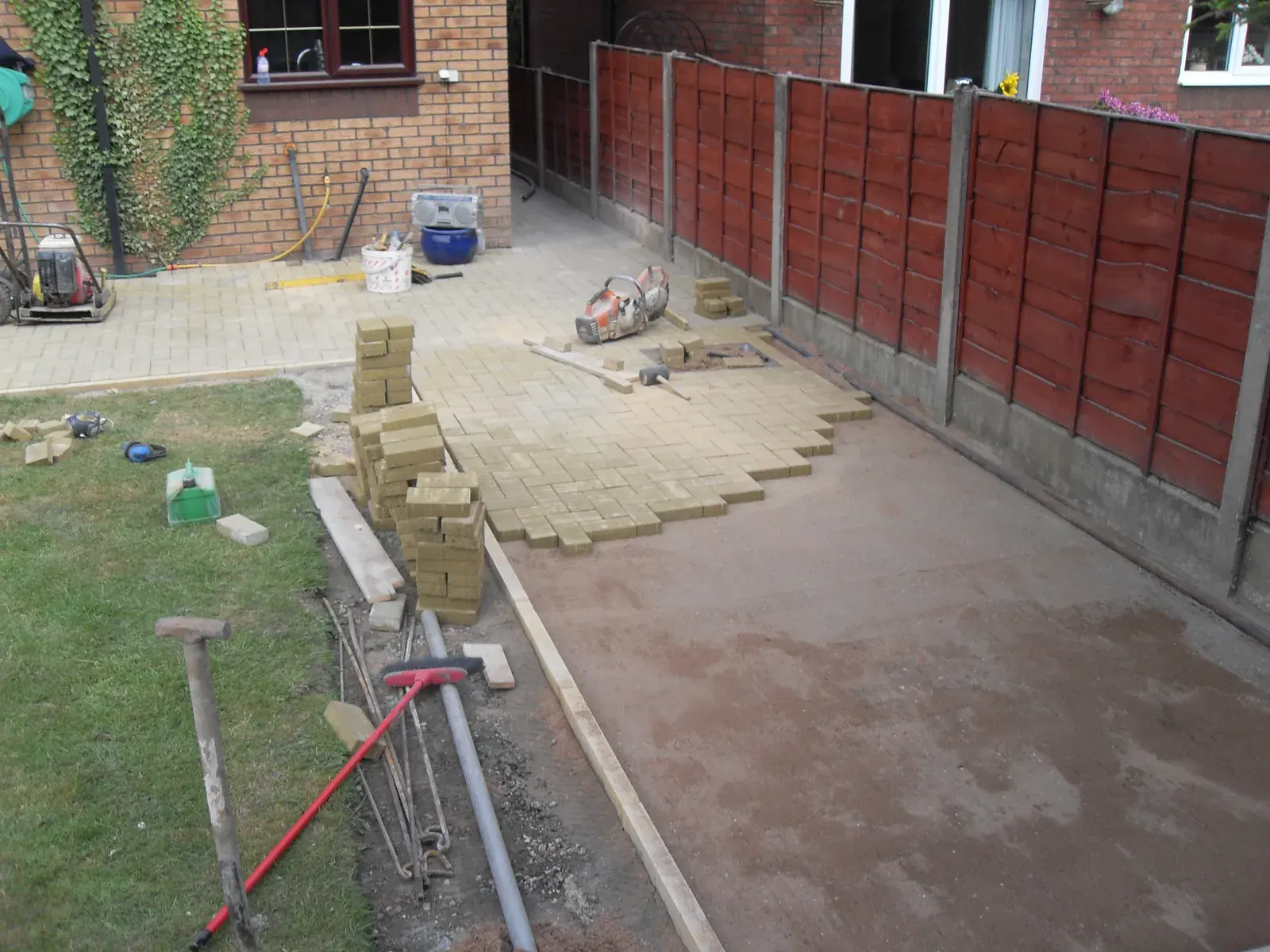Paving laid onto a prepared bed during a garden patio build