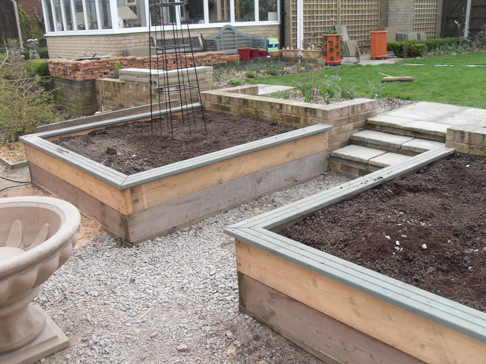 Raised timber sleeper beds and landscaping in a rear garden
