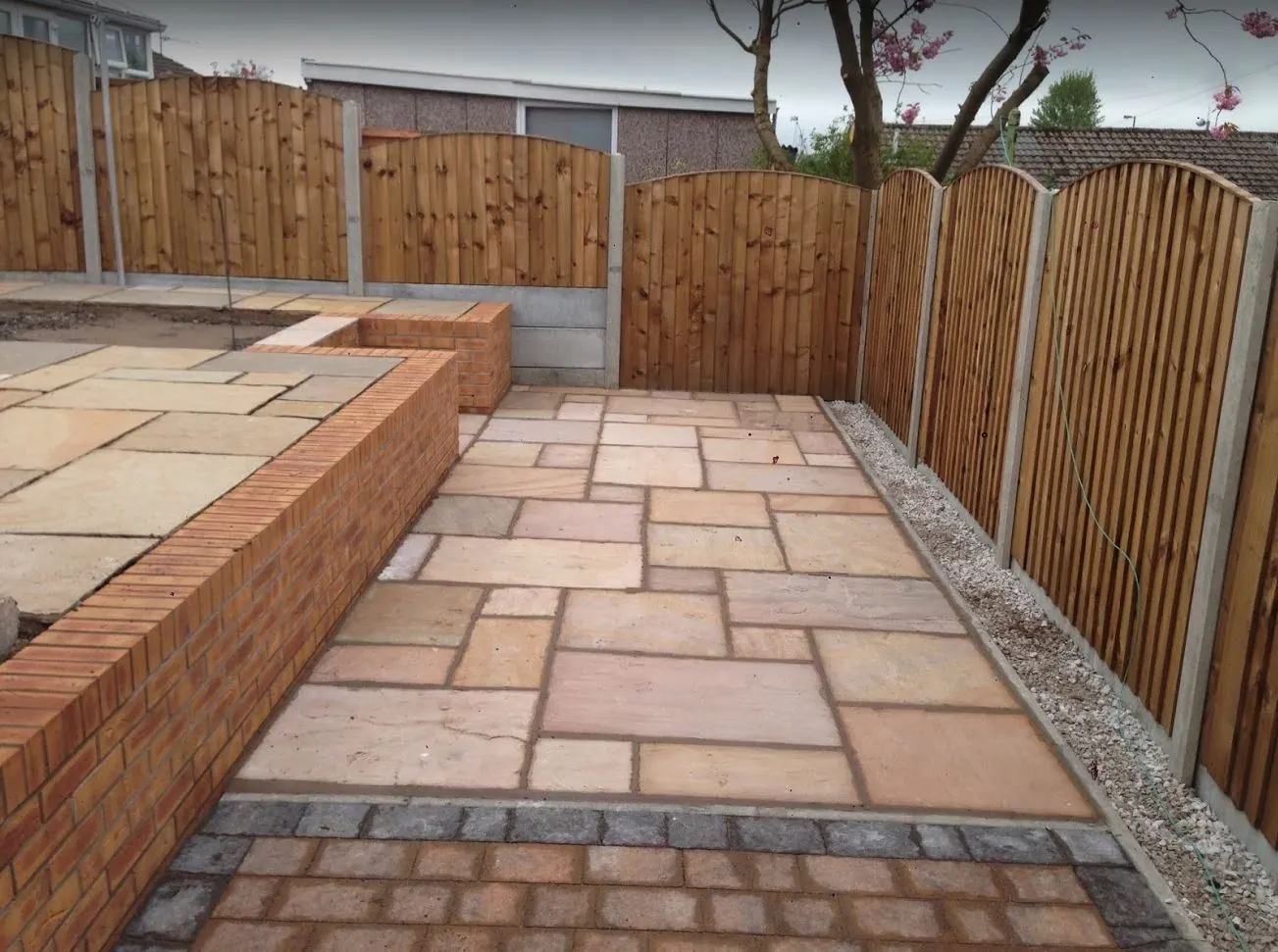 Sandstone patio with brick retaining wall and new fencing