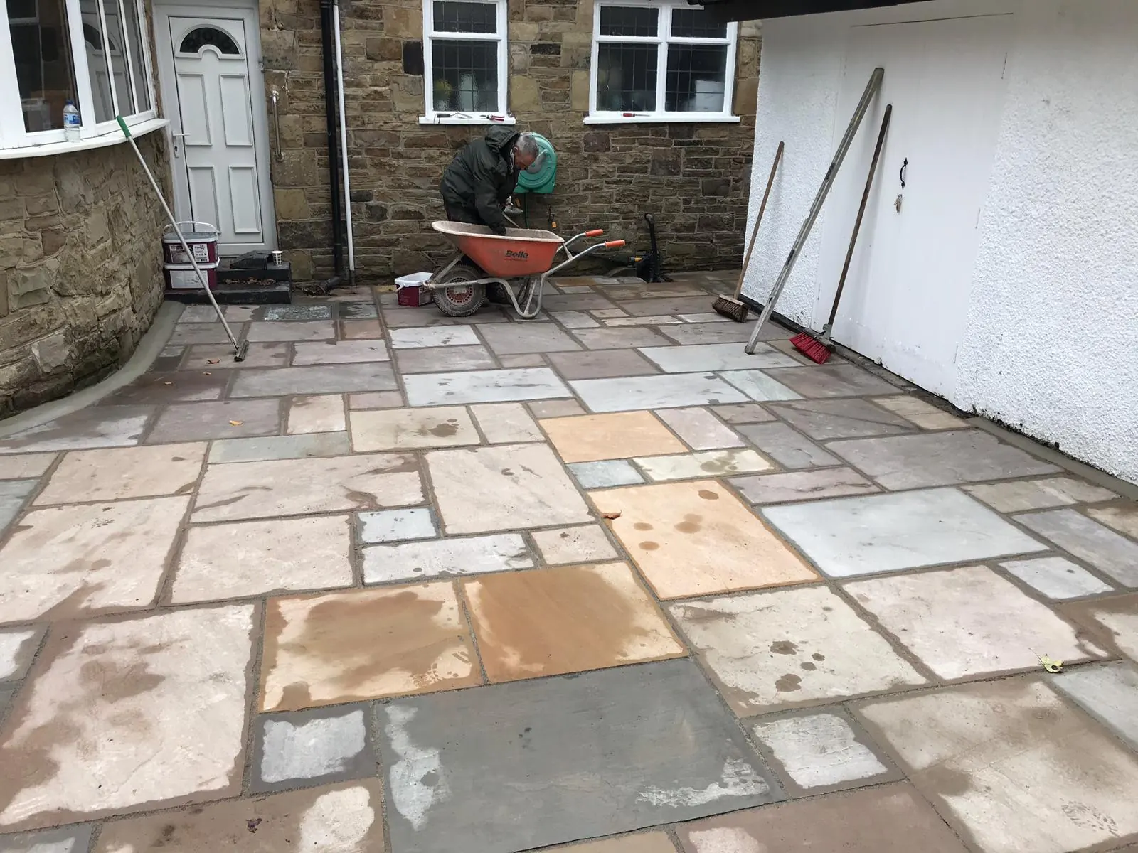 Sandstone patio laid across the full width of a house