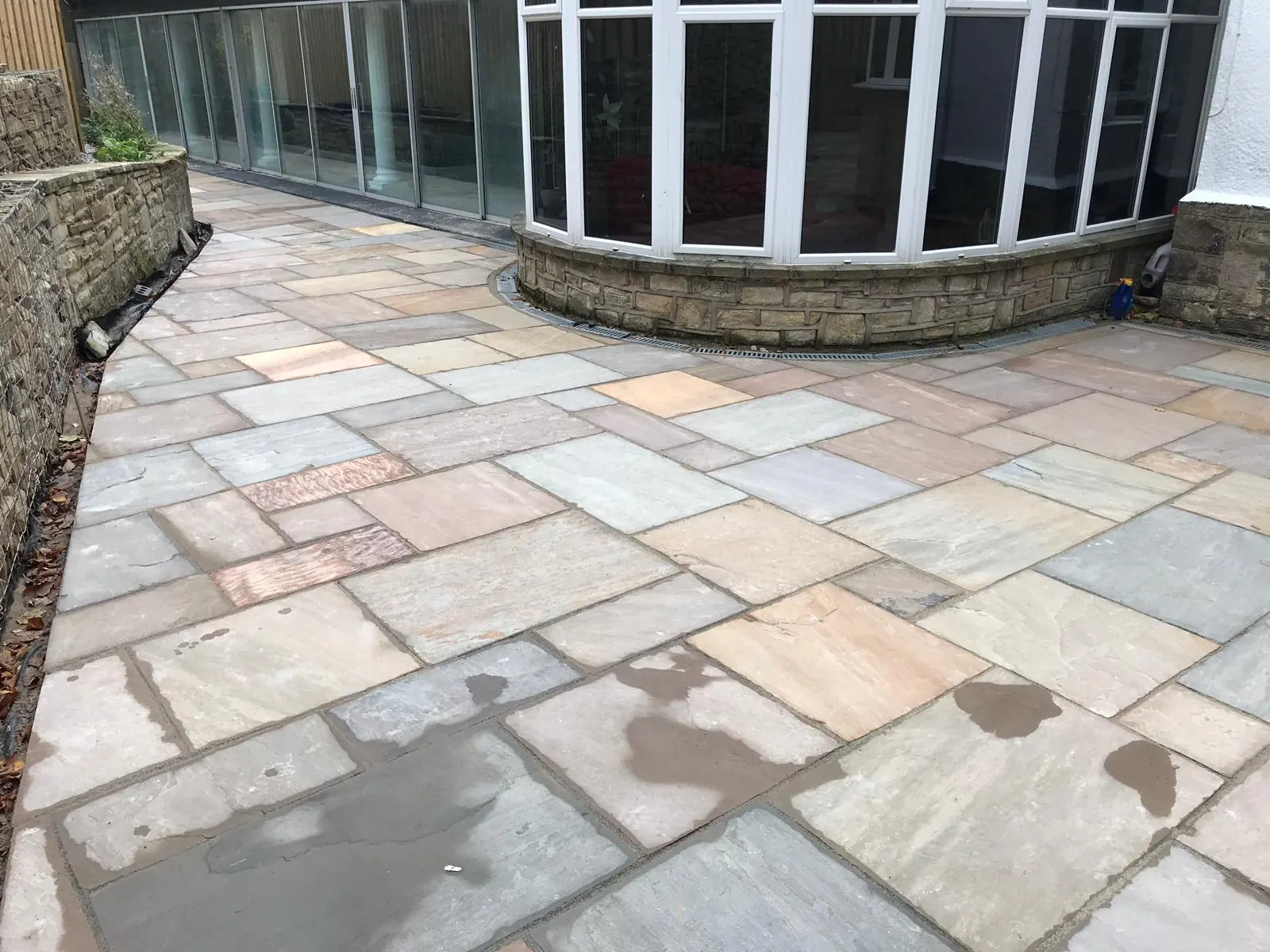 Sandstone patio laid in a sweep around a curved conservatory