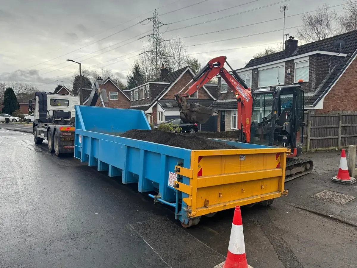 Skip container and mini digger positioned outside houses for a driveway dig out