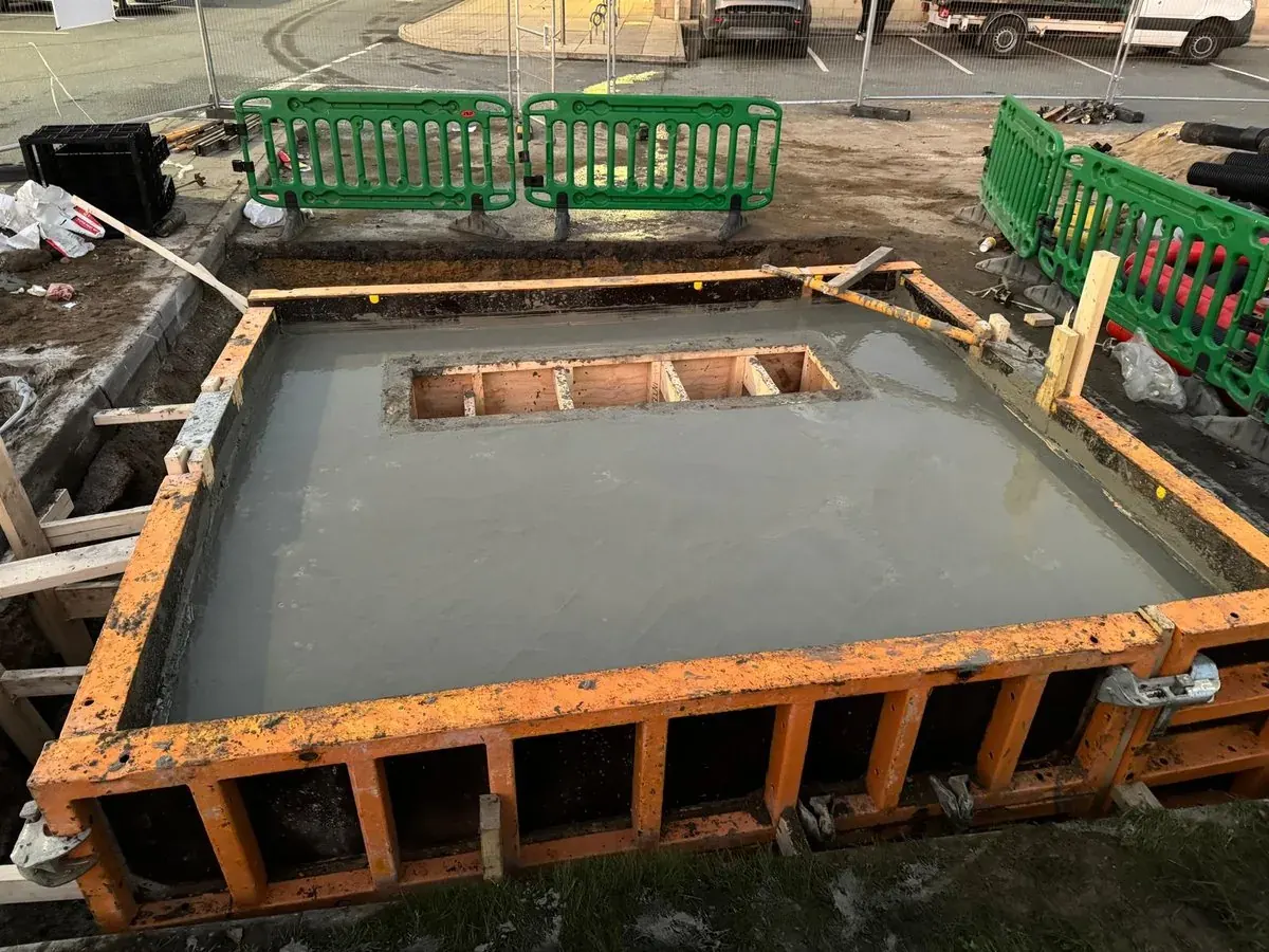 Steel shuttering set out and filled ready for a reinforced concrete foundation base