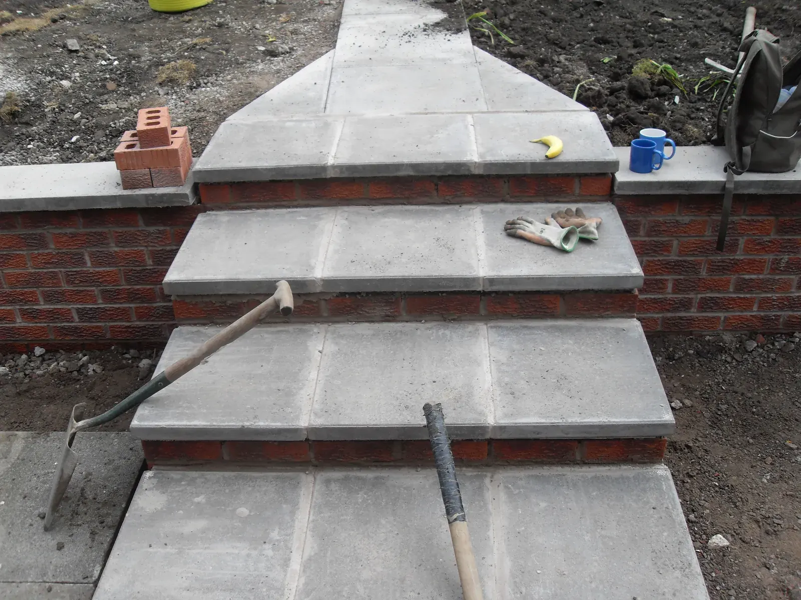 Wide concrete and paved garden steps part way through construction